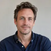 Portret van een man met kort donker haar en een lichtblauw overhemd